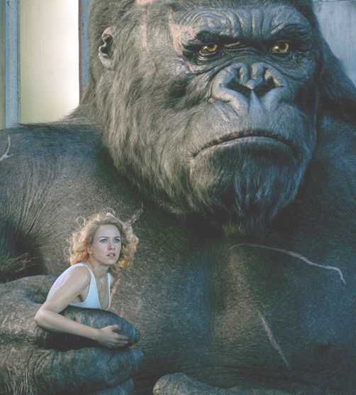 a woman standing next to a giant gorilla