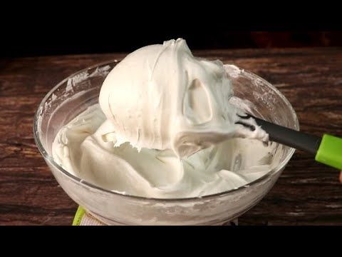 a bowl filled with whipped cream on top of a wooden table