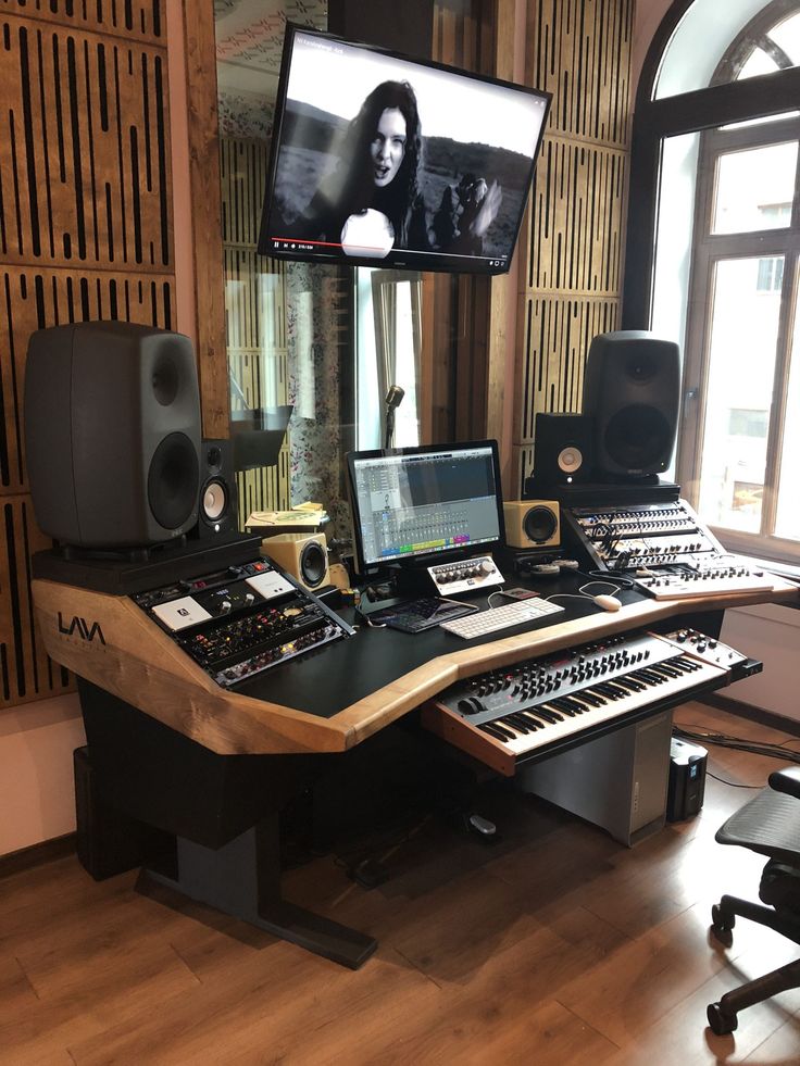 a recording studio with multiple monitors and keyboards