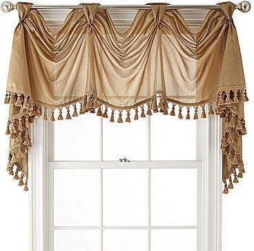 the window is decorated with tassels and flowers on it's valance