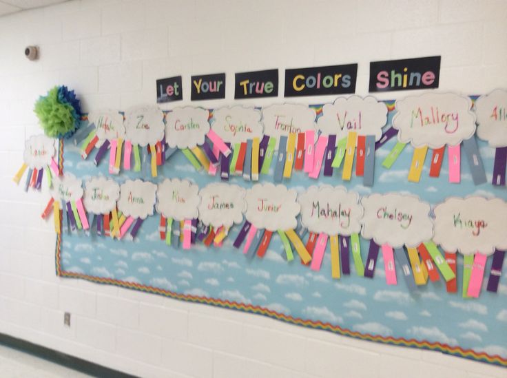 a bulletin board is decorated with colorful paper strips and rainbow pom - poms