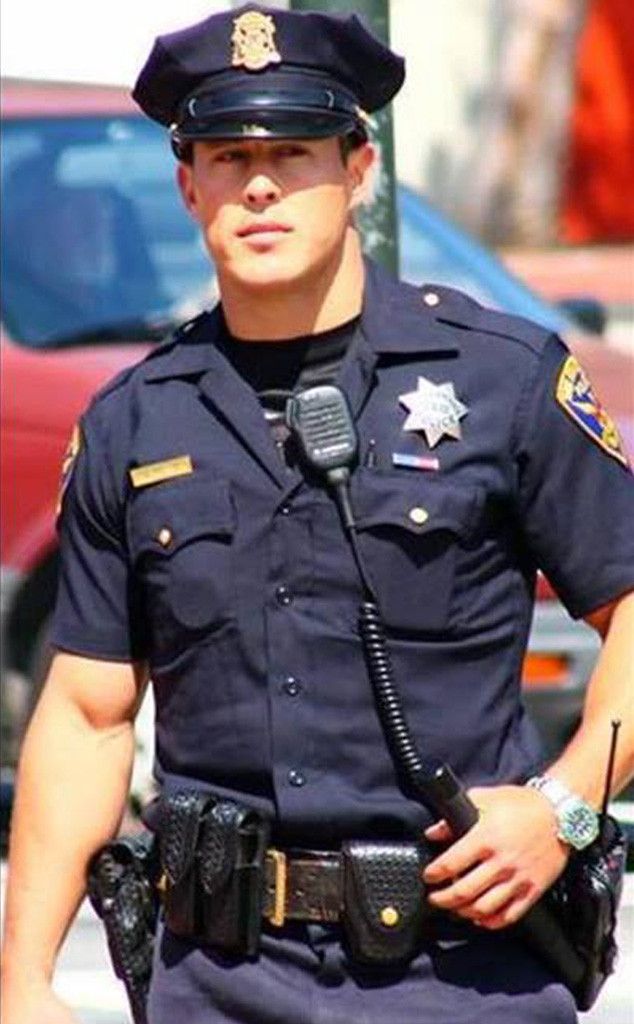 a police officer standing in front of a red car