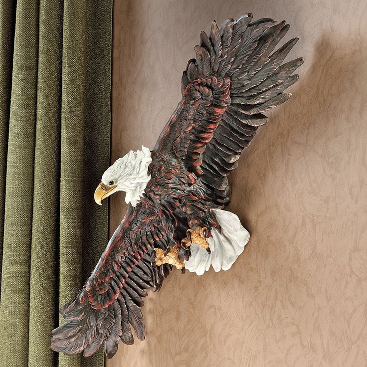 a statue of an eagle is hanging on the wall