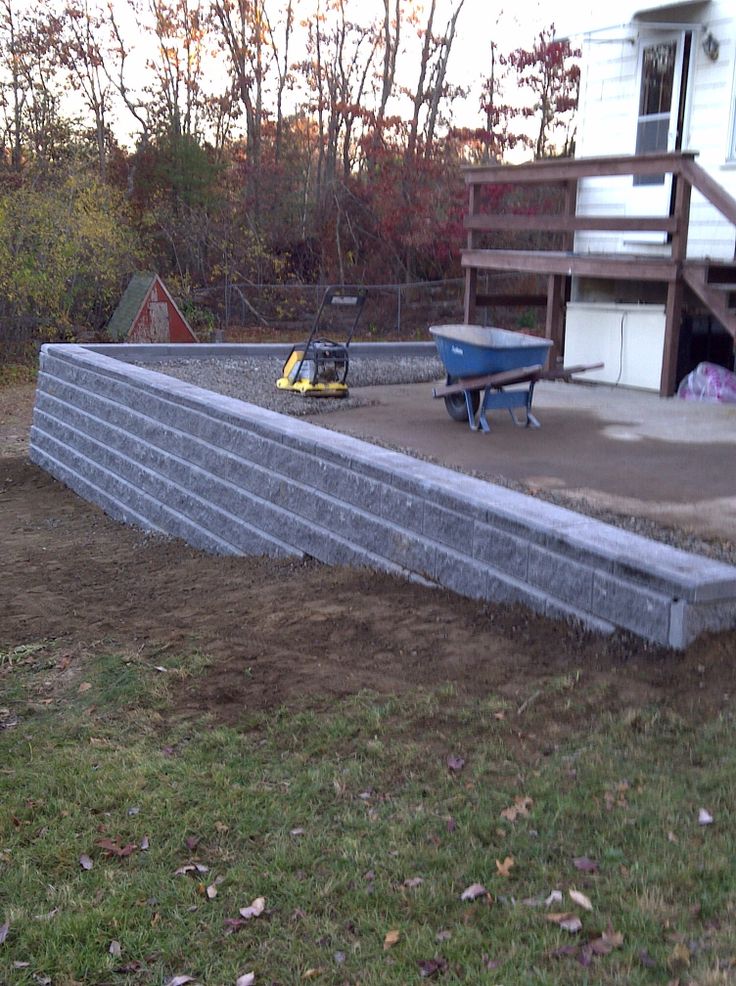 an empty yard with a ramp and two wheelbarrows on the ground next to it