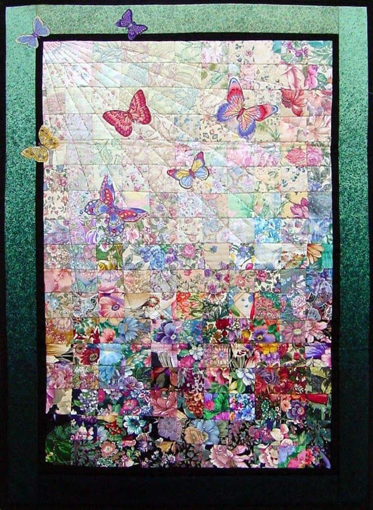 a quilted wall hanging on the side of a green frame with butterflies and flowers all over it