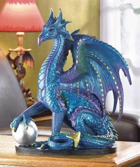 a blue dragon figurine sitting on top of a table next to a lamp