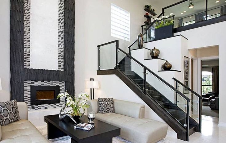 a living room filled with furniture and a fire place under a stair case next to a fireplace