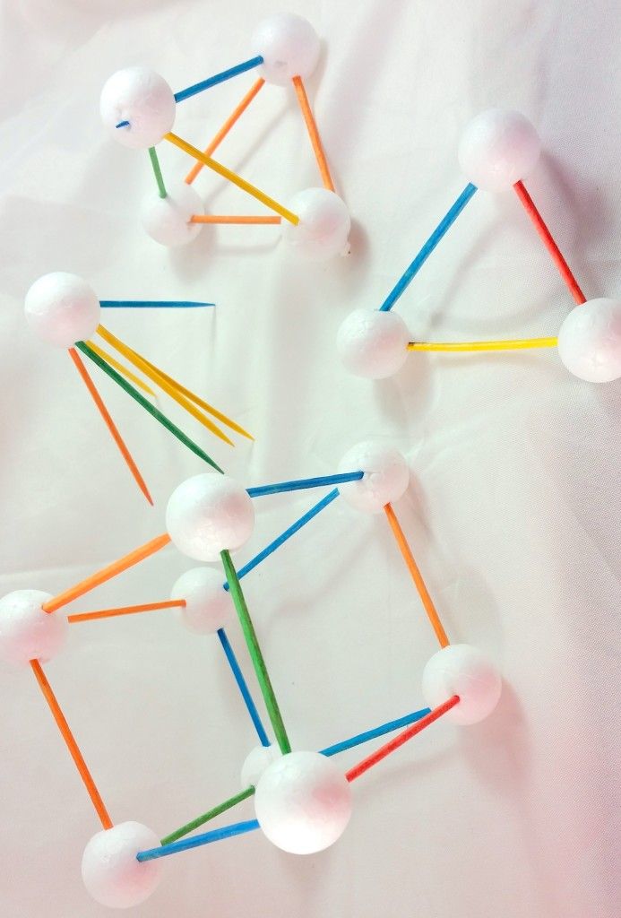 several toothpicks are arranged in the shape of an abstract structure on a white surface