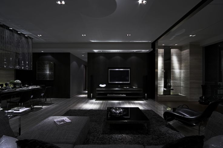 a living room with black furniture and lighting