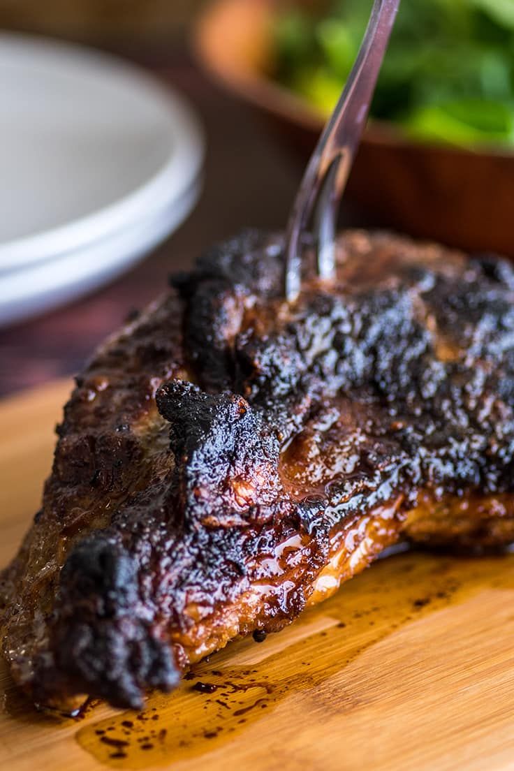 a piece of meat on a cutting board with a fork in it