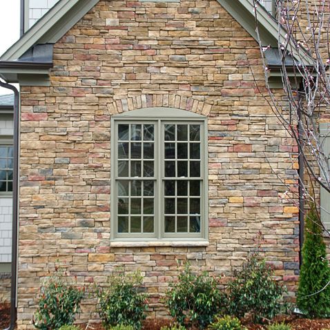 a brick building with a clock on the side of it's face and windows