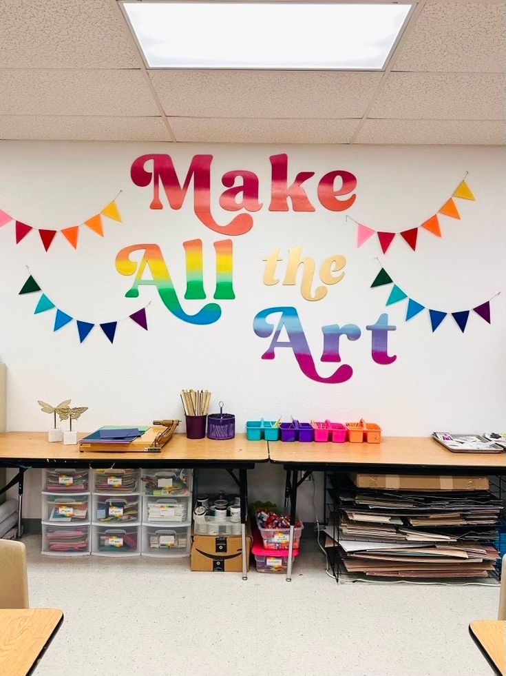 a classroom with lots of crafting supplies on the desks and in front of it is a mural that says make all the art