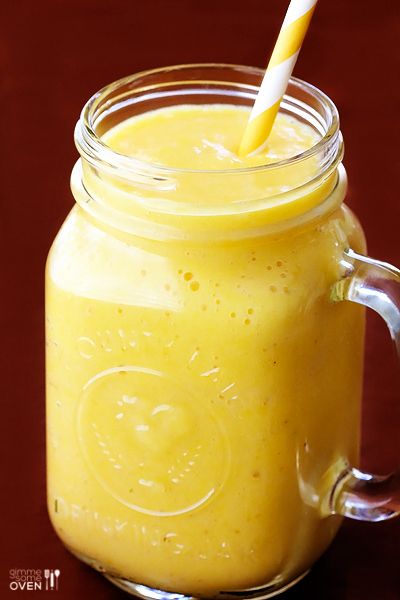 a glass jar filled with yellow liquid and a straw