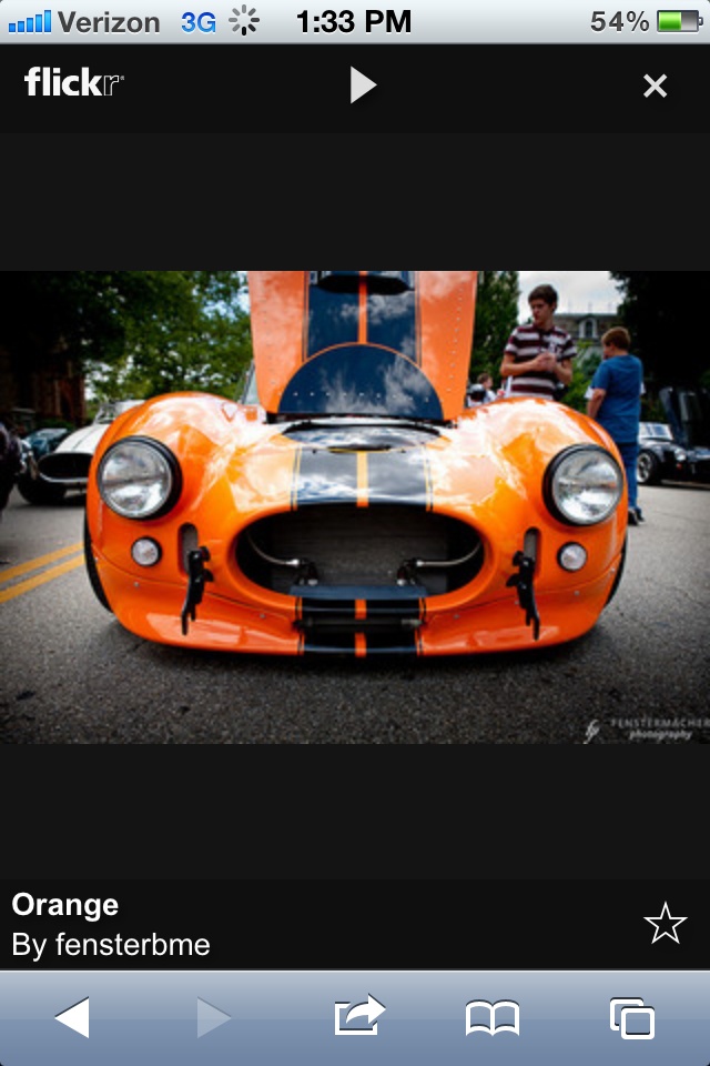 an orange sports car is parked on the street