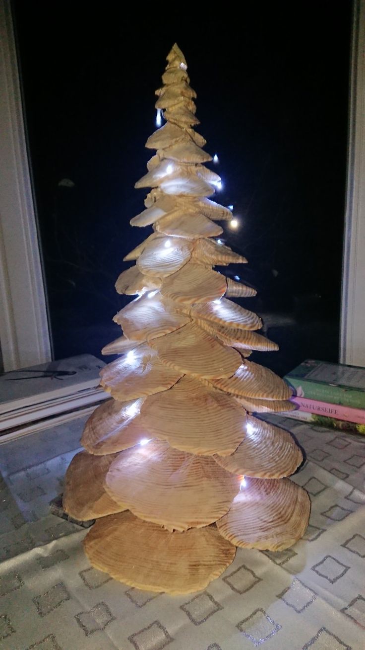 a christmas tree made out of plates on the floor in front of a window at night