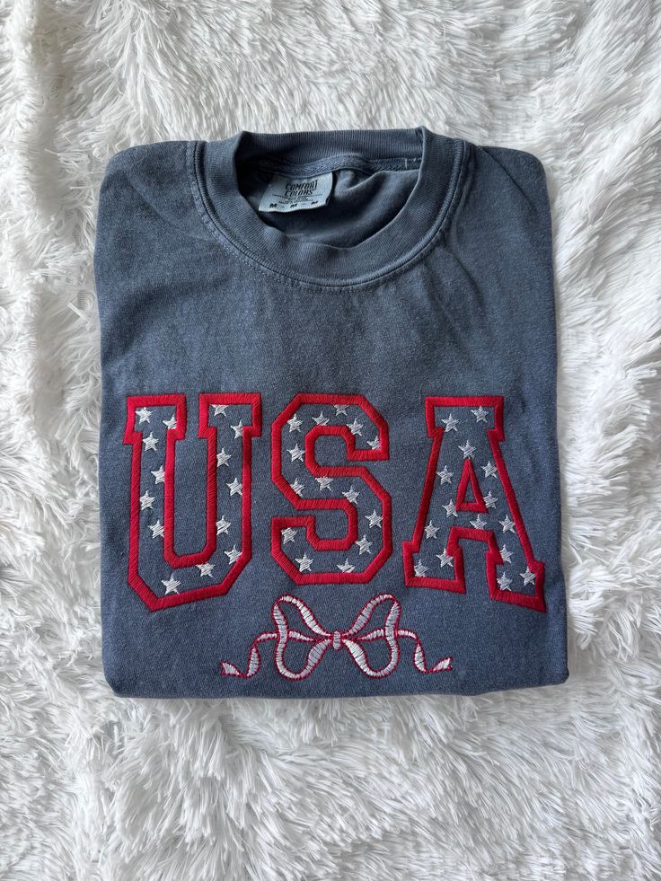 the usa t - shirt is laying on a white blanket