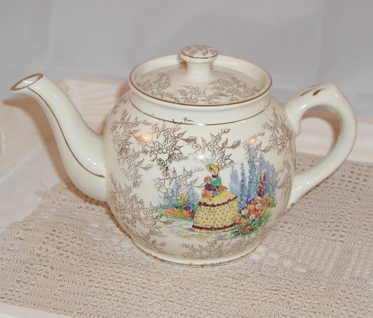 a white tea pot with a painting on it