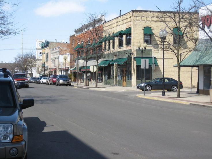 cars are parked on the street in front of shops