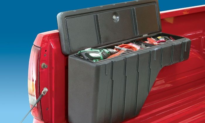 the back end of a red pickup truck with two large storage boxes on it's bed