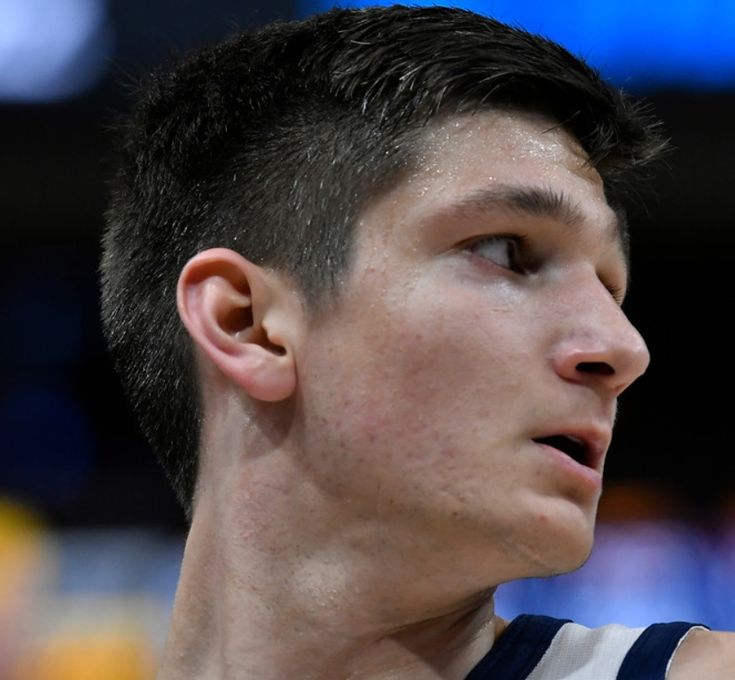 a close up of a young man wearing a jersey