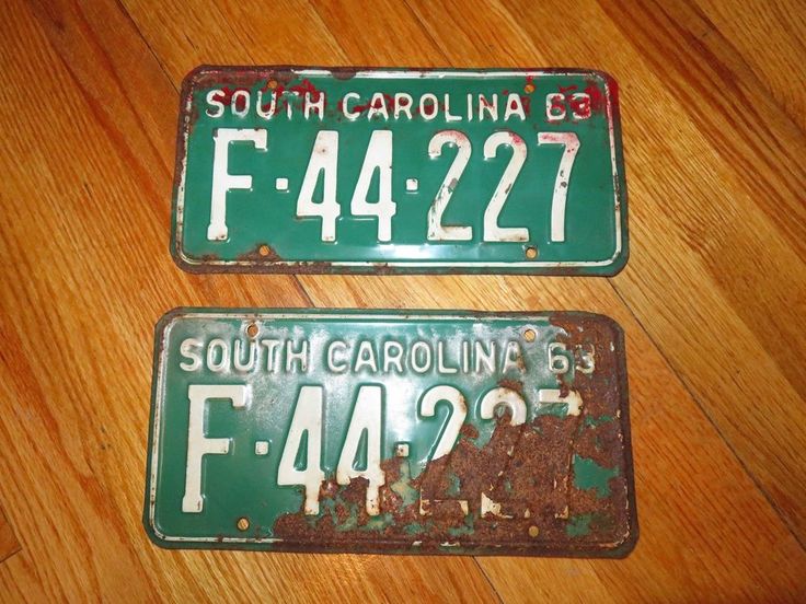 two green license plates sitting on top of a wooden floor