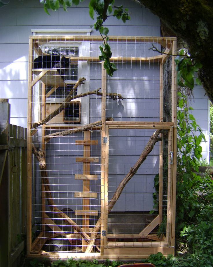 a caged in area with an orange chair next to it and a white house