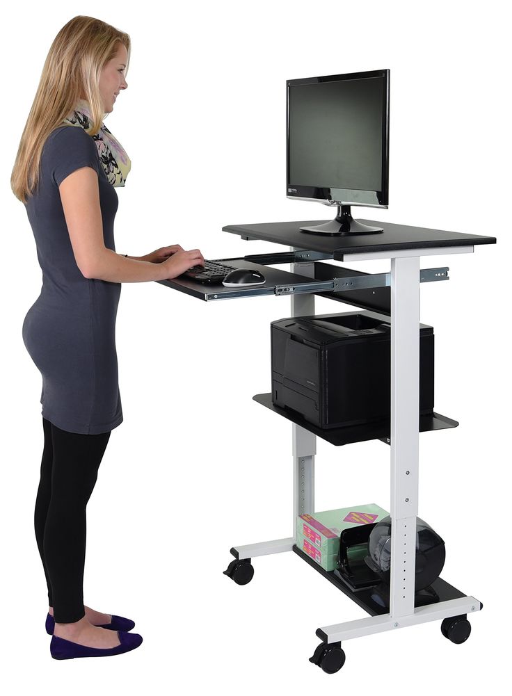 a woman standing in front of a computer desk