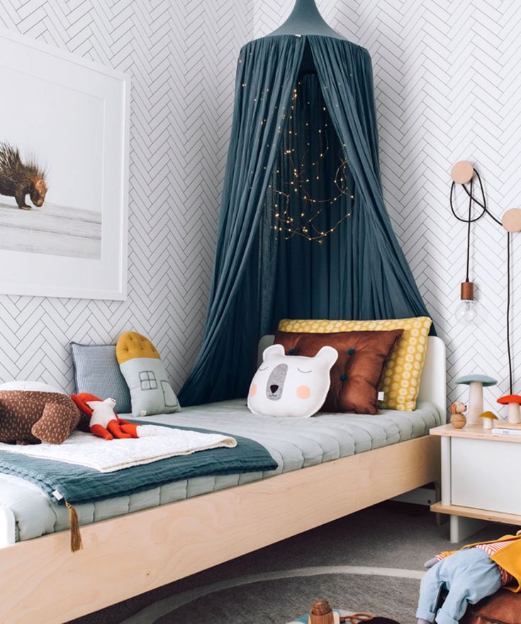 a child's bedroom with a canopy bed and toys on the floor in front of it