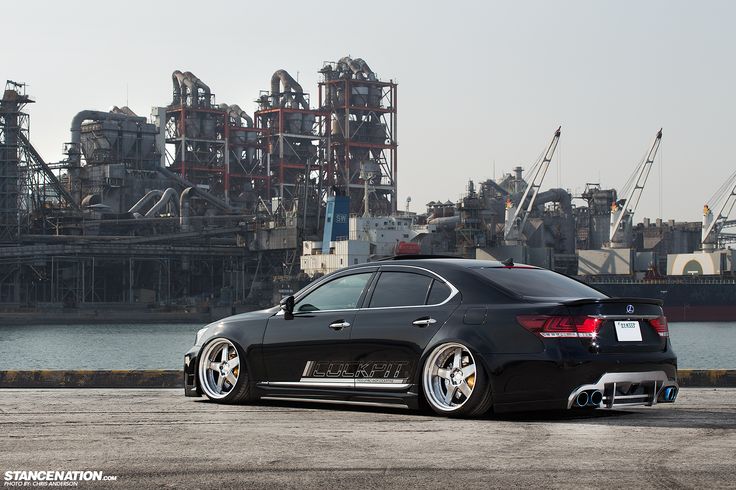 a black car parked in front of an industrial area