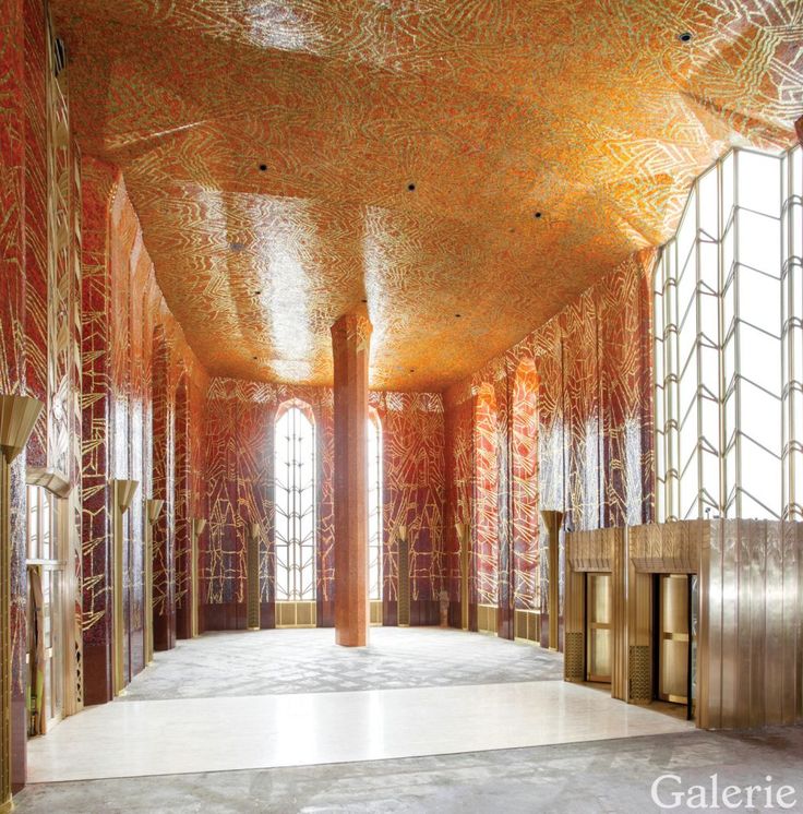 the inside of an ornate building with large windows and intricate designs on the ceiling, along with floor to ceiling glass doors