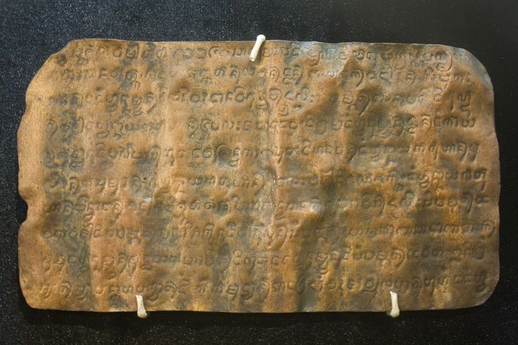 a piece of stone with writing on it sitting on a table next to a black surface