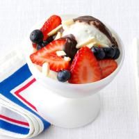 an ice cream sundae with strawberries and blueberries