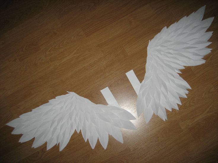 white paper angel wings sitting on top of a wooden floor