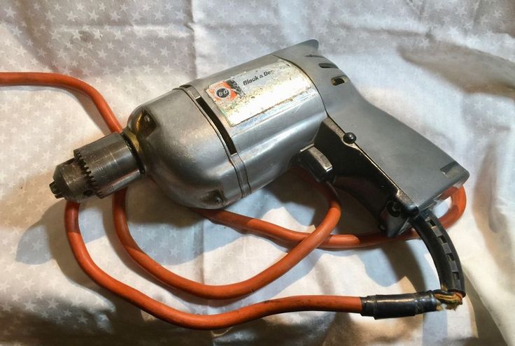 an electric blow dryer sitting on top of a white sheet with orange cords attached to it