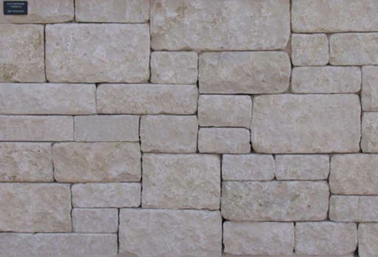 a wall made out of stone blocks with a sign on the side that says,