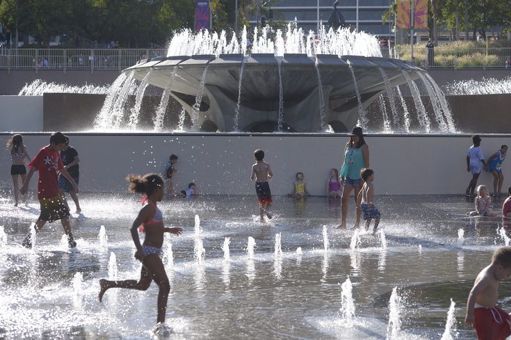 children playing in the water at a fountain