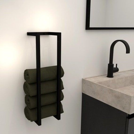 a bathroom with a sink, mirror and towel rack on the wall next to it