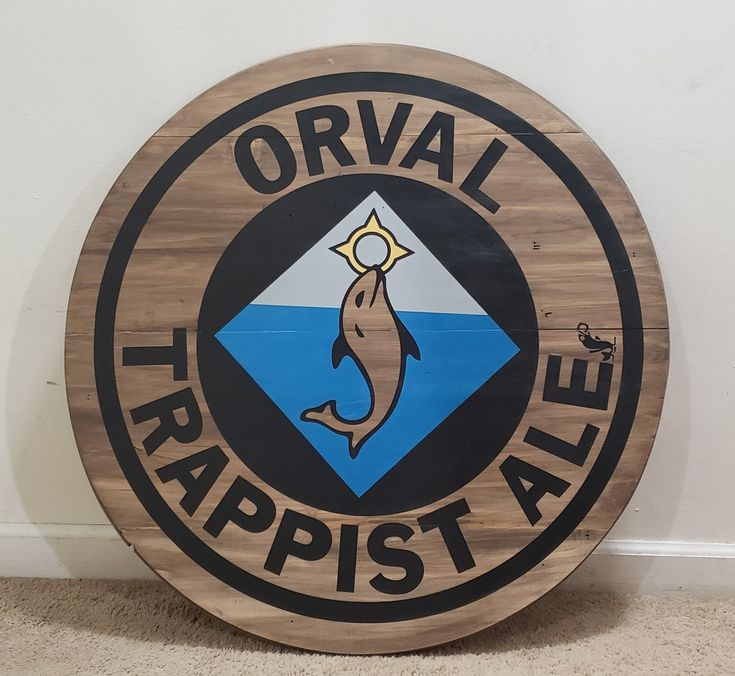 a wooden sign that says orval trappist ale on the side of a wall