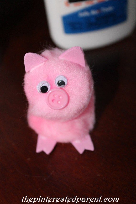 a pink toy pig sitting on top of a wooden table