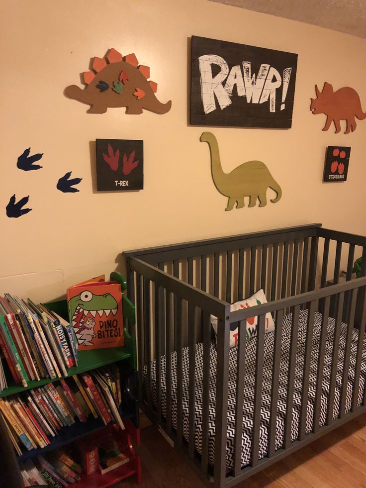 a baby's room with dinosaur decals on the wall