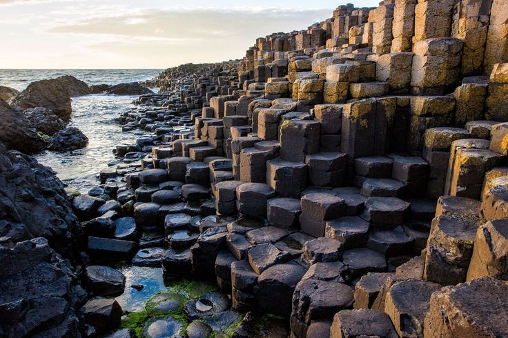 the giant rocks are stacked together on the shore