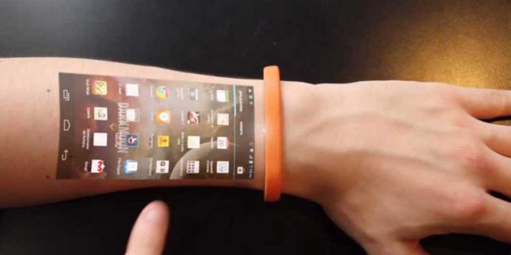 a person's arm with an orange wristband and cell phone on the wrist