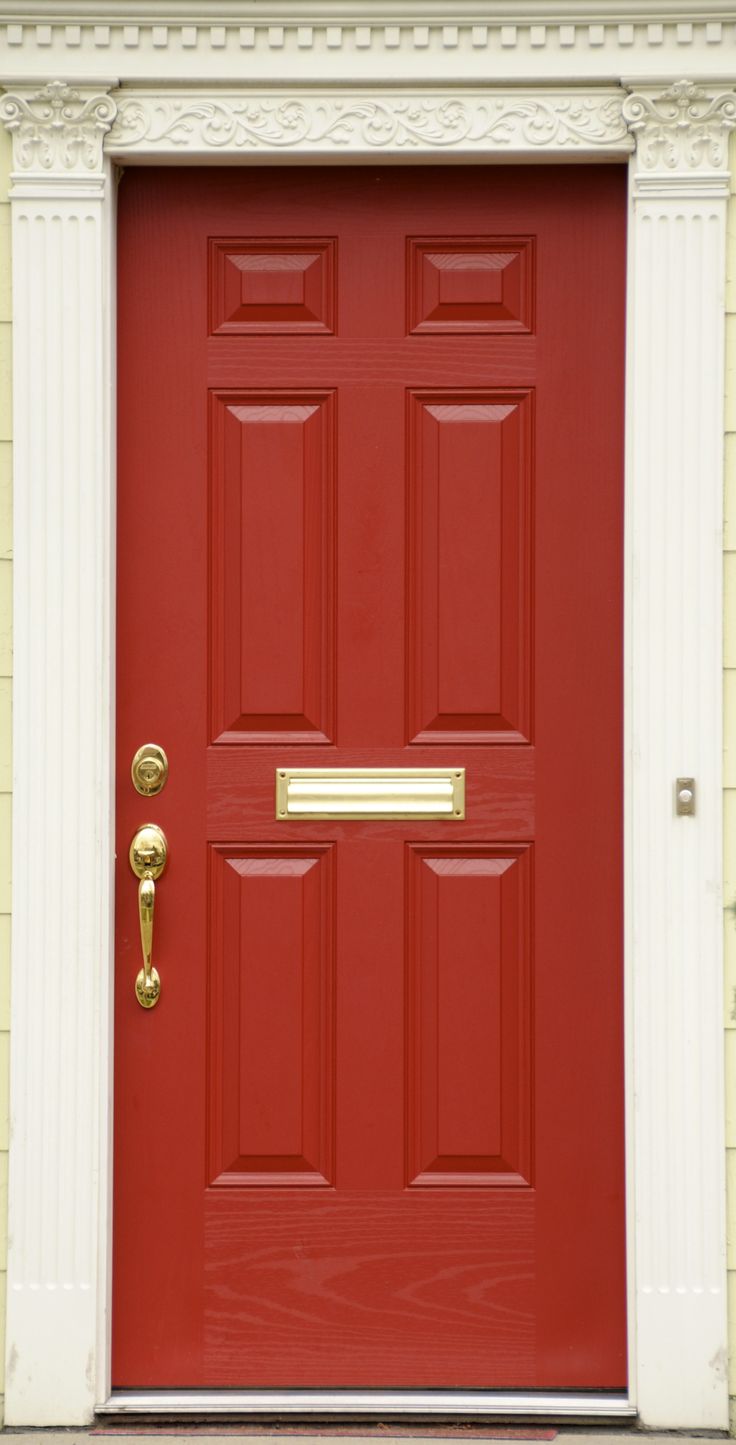 a red front door with gold handles on it