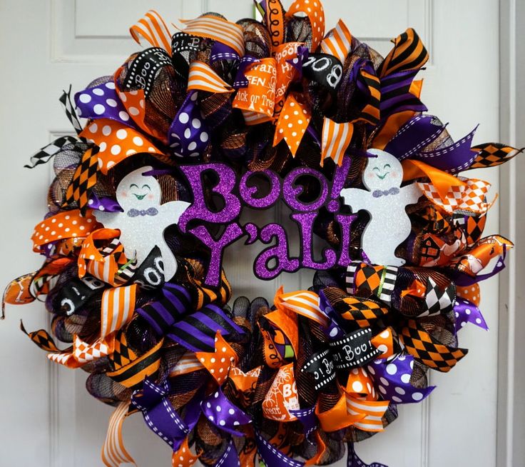 a wreath that says boo y'all on it with halloween decorations and pumpkins