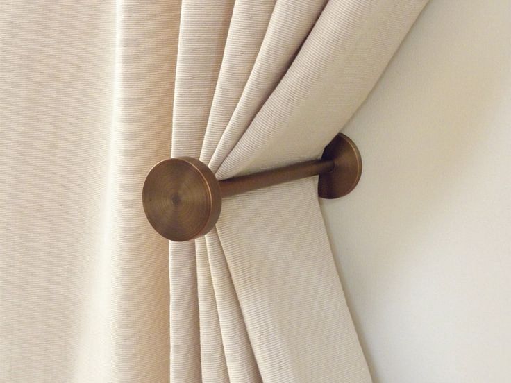 the curtain is pulled back by a pull rod with a wooden handle on it's side