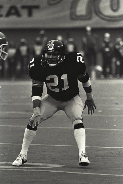 an old black and white photo of a football player