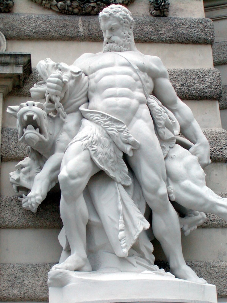 a statue of a man holding a dog on the side of a building with other statues around it