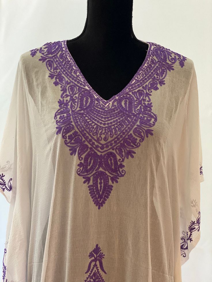 Embroidered Kashmiri Georgette Kaftan - One Size, Long. This Kaftan makes a perfect style statement for summer and your beach vacation. This is a bohemian style maxi dress that can be perfect as a swim coverup or for your beach vacations. Color: White with Purple Embroidery Fits small to plus sizes. Measurements with room for comfort: Chest up to: 50 inches Length: 55 inches Care: Hand wash or dry clean only. Bohemian Tunic With Chikankari Embroidery For Summer, Embroidered Tunic For Summer Beach Events, Embroidered Short Sleeve Tunic For Beach, Beach Tunic With Embroidery And Short Sleeves, Bohemian Kaftan With Chikankari Embroidery For Summer, Traditional Tunic Kaftan For Beach Season, White Chikankari Embroidery Kaftan For Vacation, Bohemian Dress With Chikankari Embroidery For Vacation, Bohemian Chikankari Dresses For Vacation