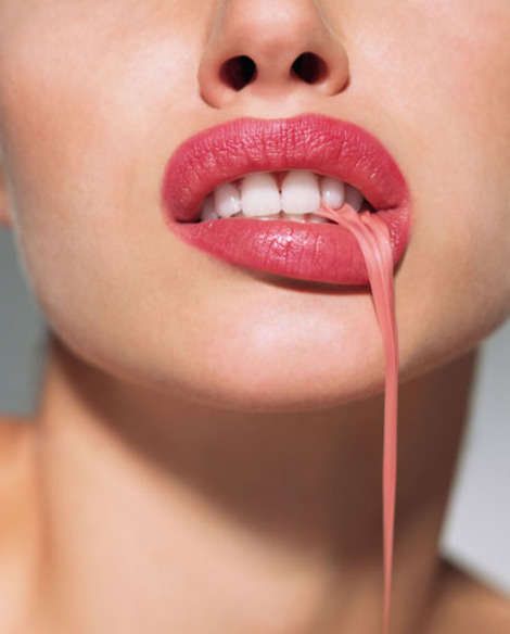 a close up of a woman's face with her tongue sticking out to the side