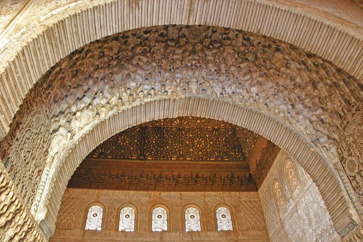 an arch in the middle of a building with decorative carvings on it's walls